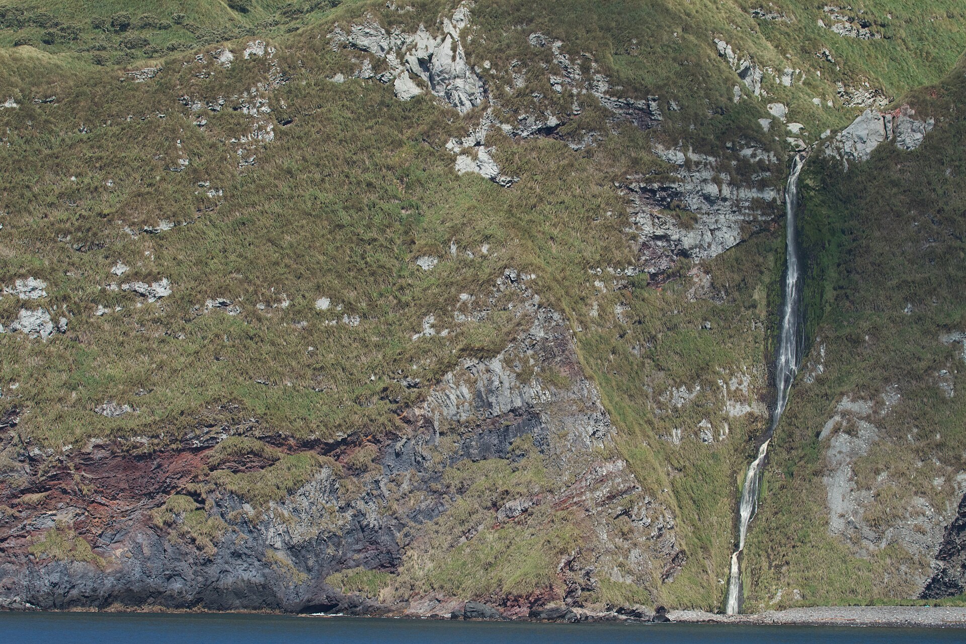 A waterfall pouring over the cliffs of Inaccessible Island